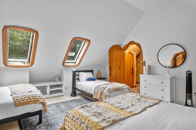 tiled bedroom with vaulted ceiling with skylight