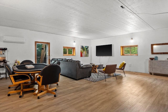 dining room with a wall mounted air conditioner and light wood-type flooring