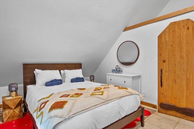 bedroom with vaulted ceiling and tile flooring