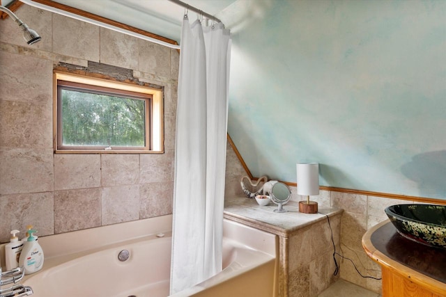 bathroom with shower / bathtub combination with curtain and tile walls