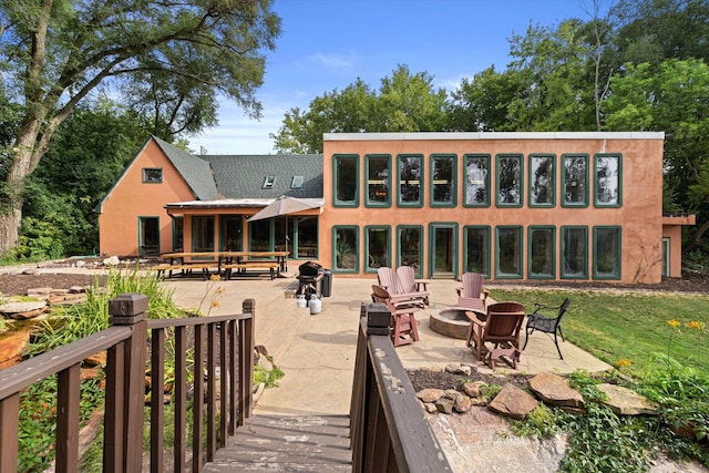 back of property featuring a patio area and a fire pit