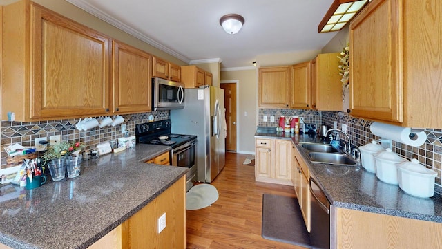 kitchen with sink, appliances with stainless steel finishes, tasteful backsplash, and light hardwood / wood-style flooring