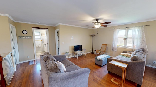 living room featuring dark hardwood / wood-style floors, ceiling fan, and crown molding