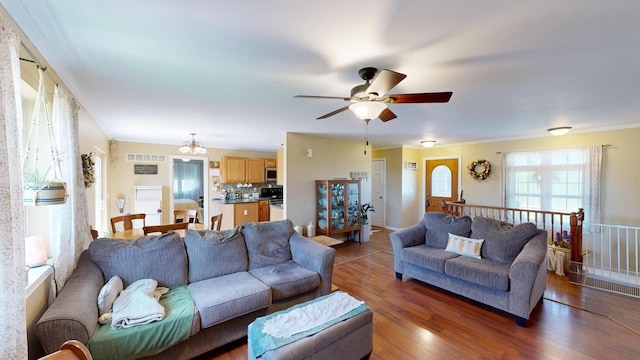 living room featuring hardwood / wood-style floors, ceiling fan, and ornamental molding