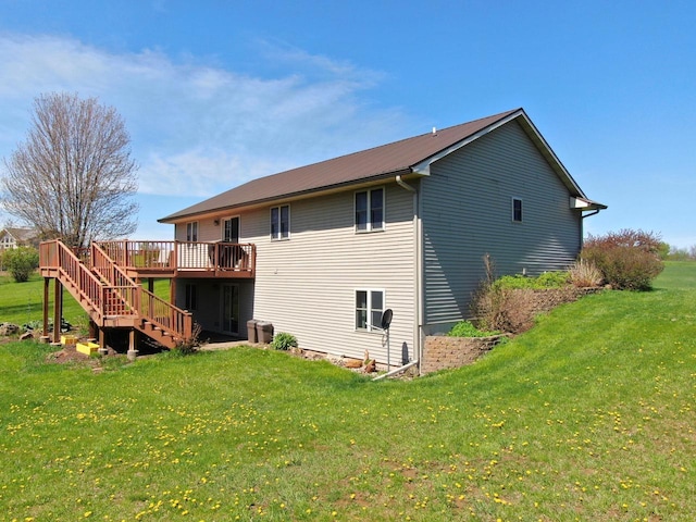 rear view of house with a deck and a lawn