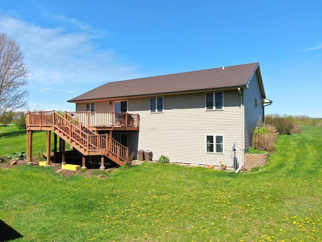 rear view of property with a wooden deck and a lawn