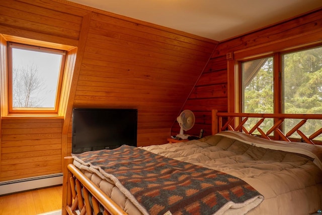 bedroom featuring a baseboard radiator, vaulted ceiling, hardwood / wood-style flooring, and wooden walls