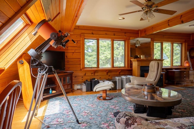 living room featuring a skylight, ceiling fan, and light wood-type flooring