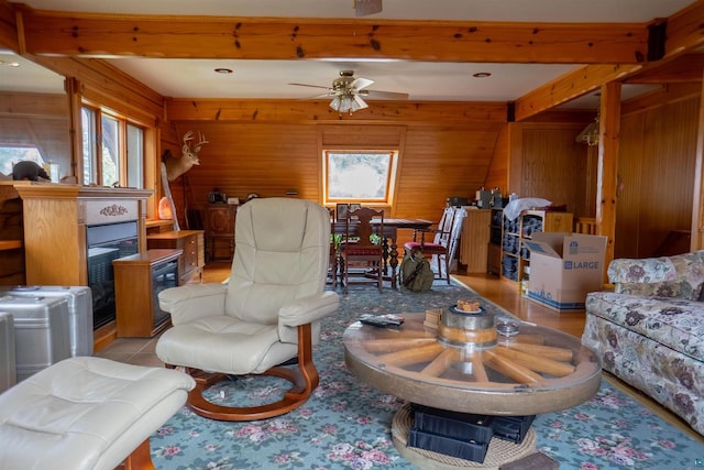 living room featuring wood walls, ceiling fan, and a wealth of natural light