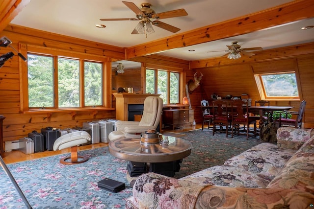 living room featuring hardwood / wood-style floors, wood walls, ceiling fan, and baseboard heating