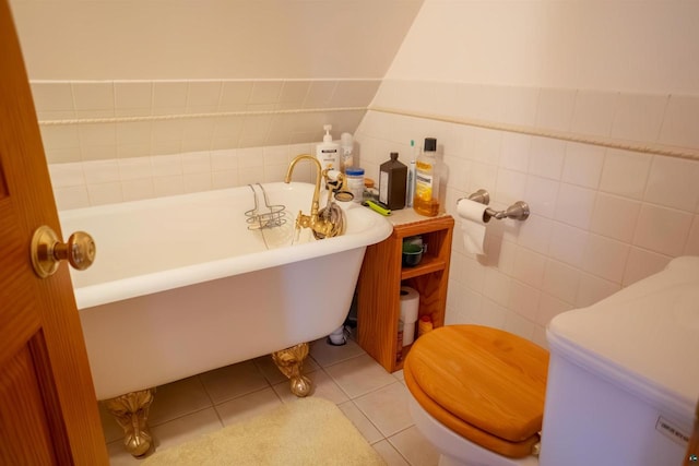 bathroom with tile walls, a tub, tile floors, and toilet