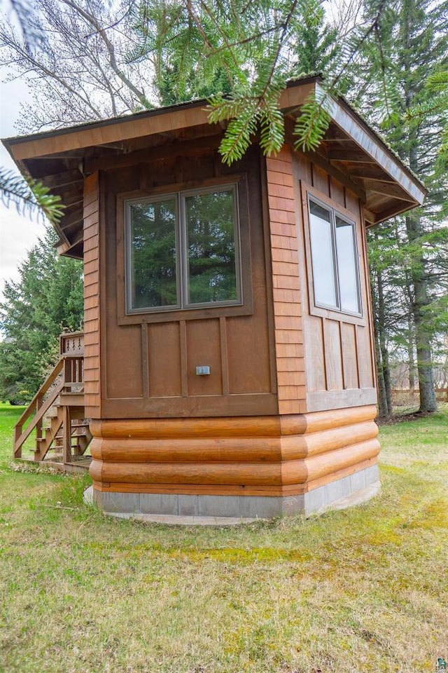 view of side of home featuring a lawn and an outdoor structure