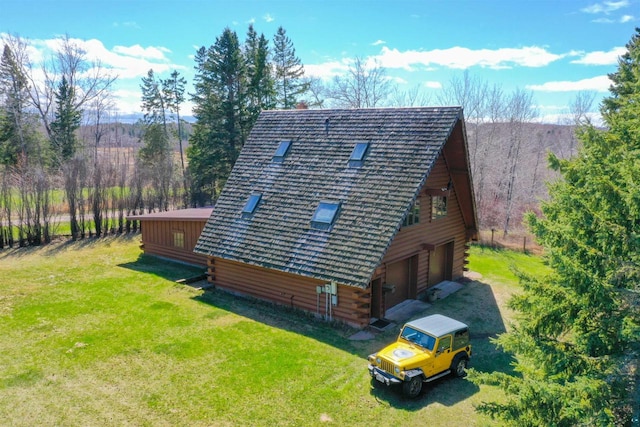 back of property with a garage and a lawn