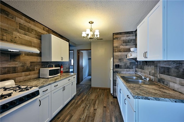 kitchen featuring white cabinetry, white appliances, dark wood-type flooring, wooden walls, and sink