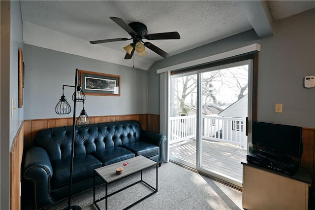 living room featuring ceiling fan, carpet, and a textured ceiling