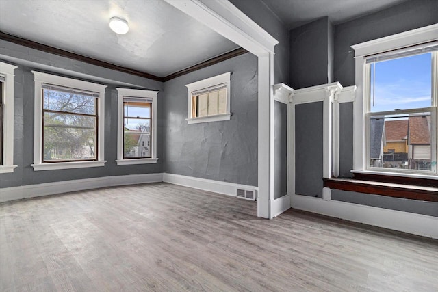 empty room featuring light hardwood / wood-style flooring and ornamental molding