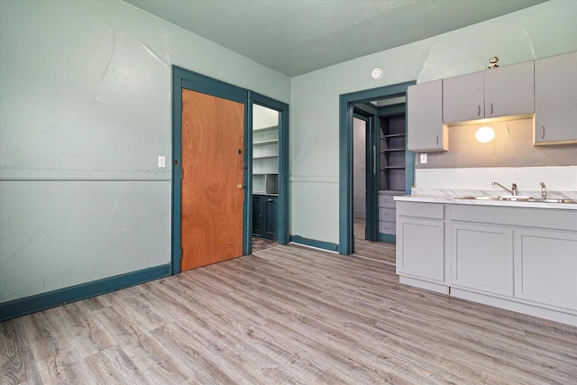 kitchen featuring gray cabinetry, light wood-type flooring, and sink