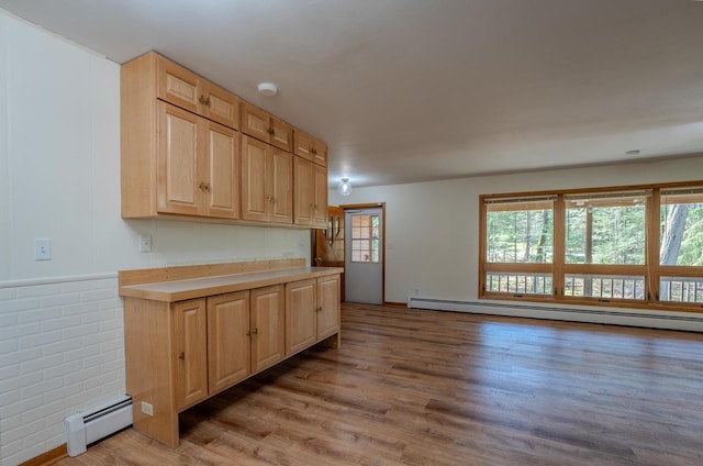 kitchen featuring hardwood / wood-style flooring, a healthy amount of sunlight, a baseboard radiator, and light brown cabinetry