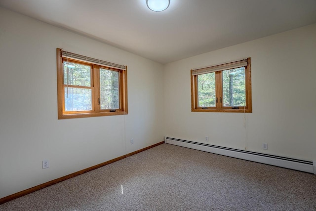 empty room with carpet floors and a baseboard heating unit