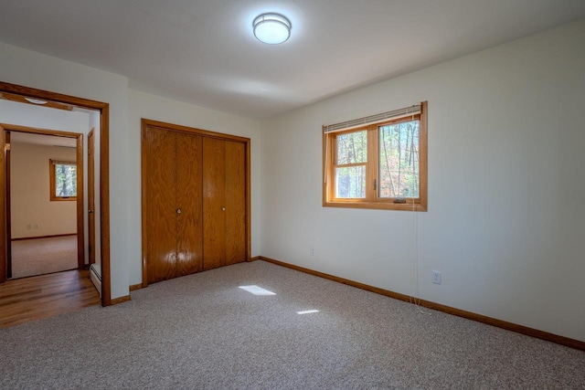 unfurnished bedroom with a closet, wood-type flooring, and multiple windows