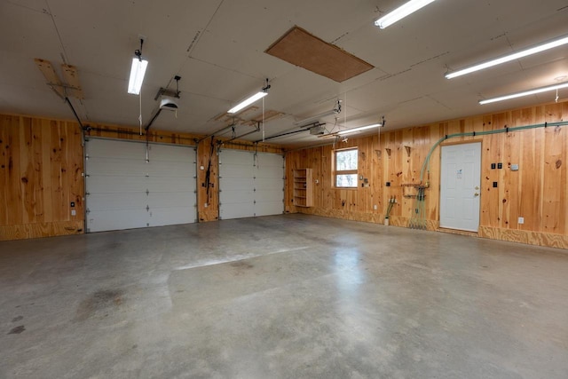 garage featuring wood walls and a garage door opener