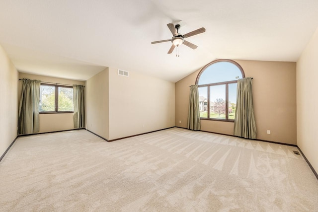 carpeted spare room featuring ceiling fan and vaulted ceiling