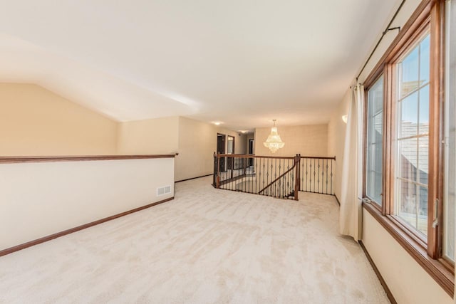 carpeted empty room featuring vaulted ceiling