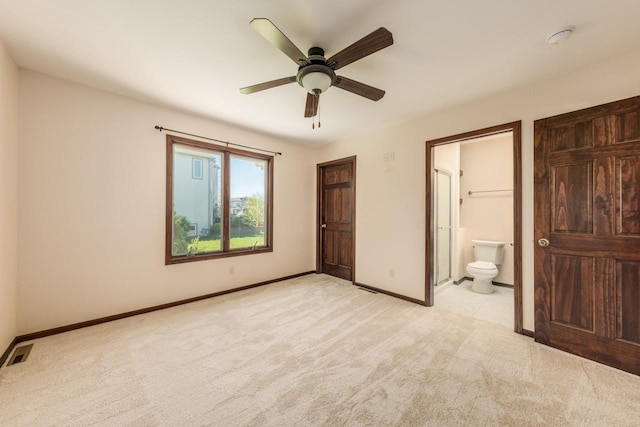 unfurnished bedroom with ensuite bath, ceiling fan, and light carpet