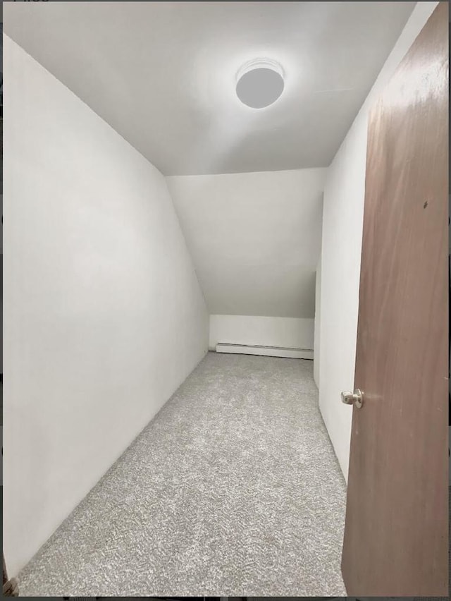 additional living space featuring lofted ceiling and baseboard heating