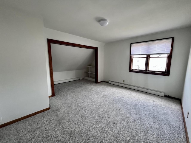 bonus room with carpet flooring and a baseboard heating unit