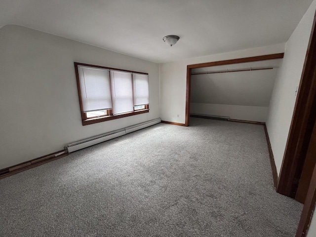 carpeted spare room featuring a baseboard heating unit