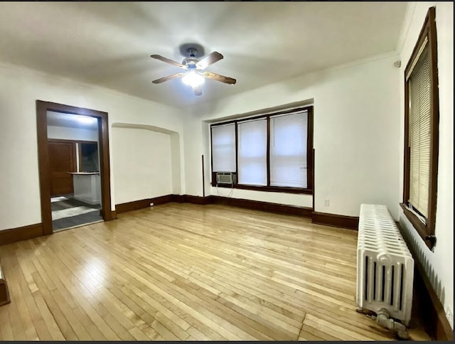 unfurnished bedroom featuring ceiling fan, light hardwood / wood-style floors, radiator heating unit, and cooling unit