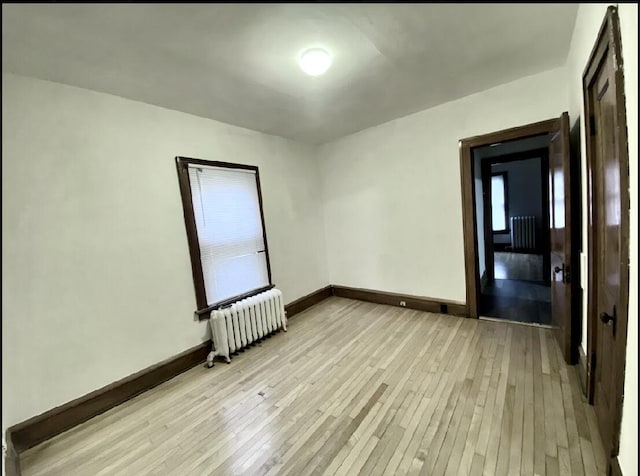 unfurnished room featuring light hardwood / wood-style floors and radiator