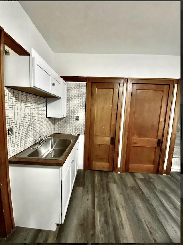 kitchen featuring decorative backsplash, white cabinetry, sink, and dark wood-type flooring