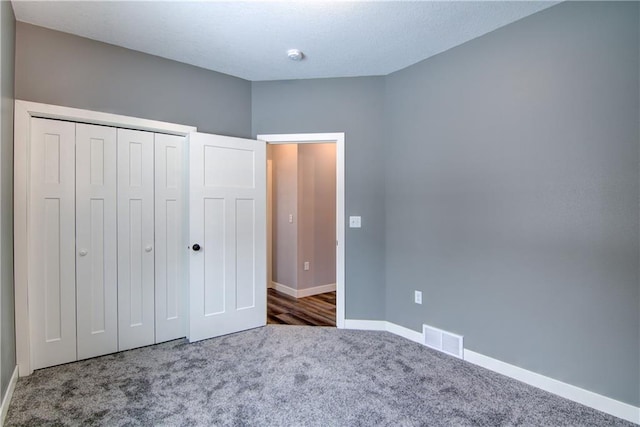 unfurnished bedroom with carpet flooring and a closet