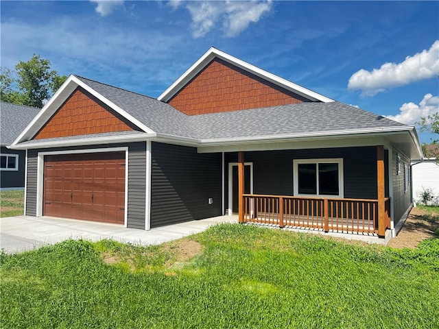 view of front of home featuring a garage, covered porch, and a front yard