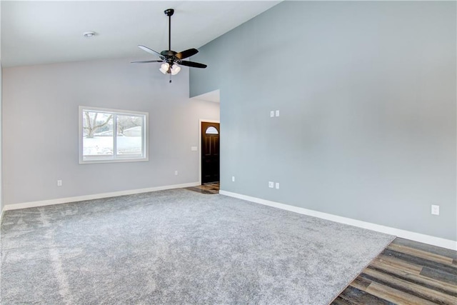 carpeted empty room with high vaulted ceiling and ceiling fan