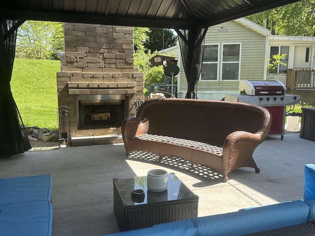 view of patio with area for grilling and an outdoor living space with a fireplace