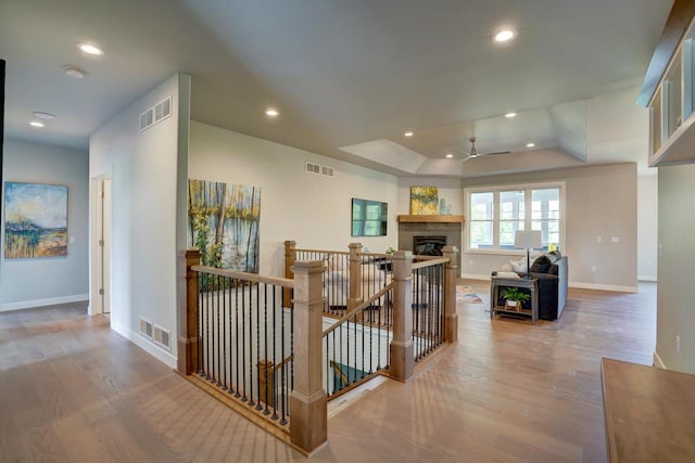 corridor featuring a raised ceiling and hardwood / wood-style flooring