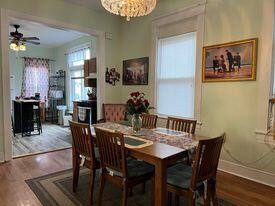 dining room with hardwood / wood-style flooring and ceiling fan with notable chandelier