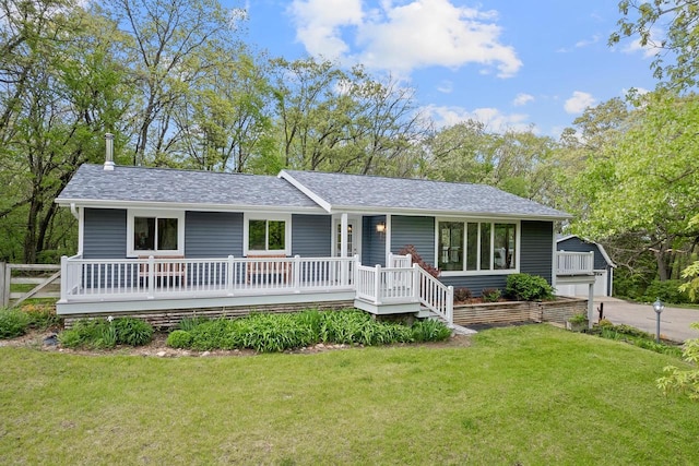 single story home with a front lawn, an outdoor structure, and a garage