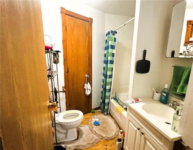 full bathroom featuring hardwood / wood-style flooring, toilet, shower / bath combination with curtain, and vanity