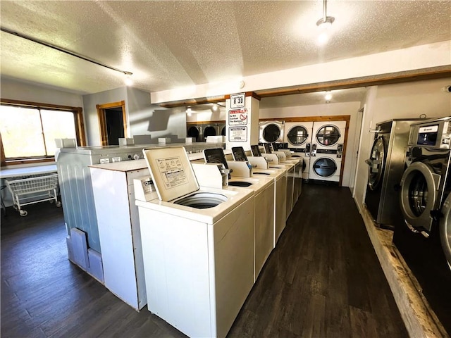 laundry area featuring dark wood-type flooring, stacked washing maching and dryer, and a textured ceiling