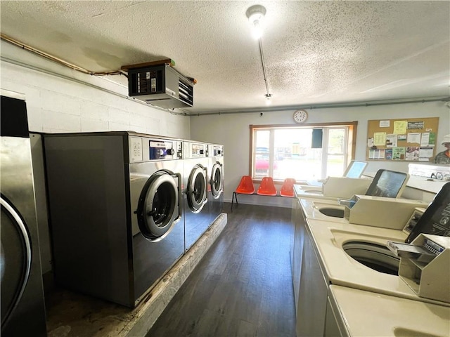 laundry room with a textured ceiling, dark wood-type flooring, and washing machine and clothes dryer