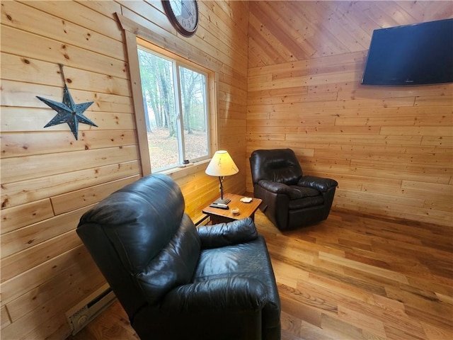 living area with hardwood / wood-style flooring, baseboard heating, and wooden walls