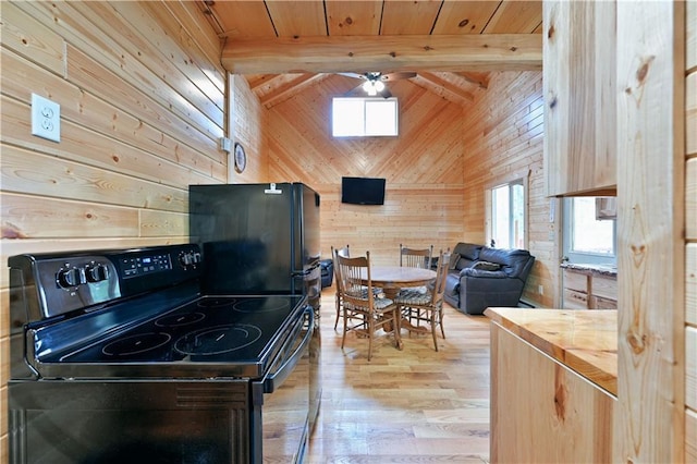 kitchen featuring electric stove, ceiling fan, light wood-type flooring, and wooden walls