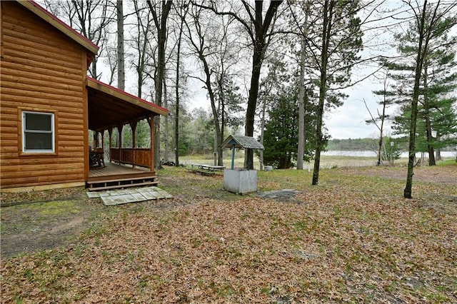 view of yard with a deck with water view