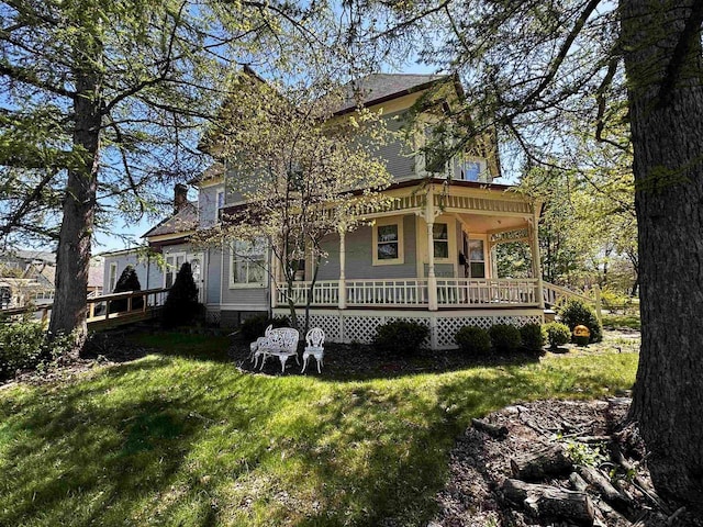 back of property featuring a lawn and a porch