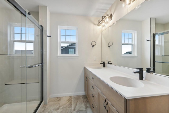 bathroom with vanity, a healthy amount of sunlight, and an enclosed shower