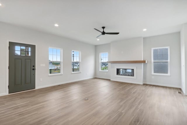 unfurnished living room with ceiling fan and light hardwood / wood-style flooring